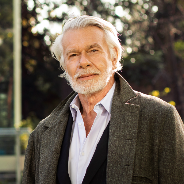 Portrait of the blog owner with face partially distorted through two clear glasses of water on a white table